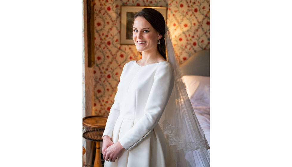 The bride in her silk long sleeve wedding dress.