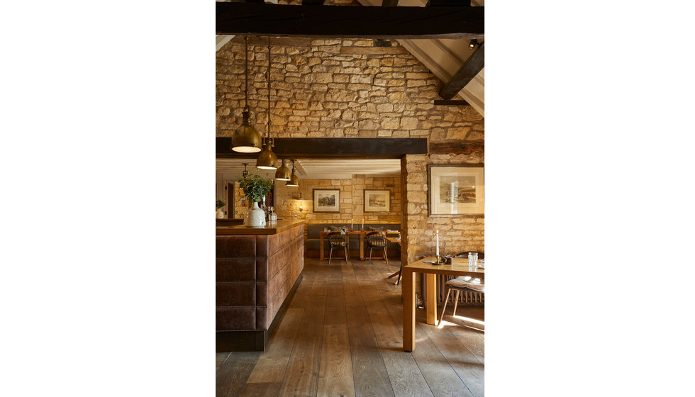 The dining room in the Dormy House Hotel with exposed brick walls.