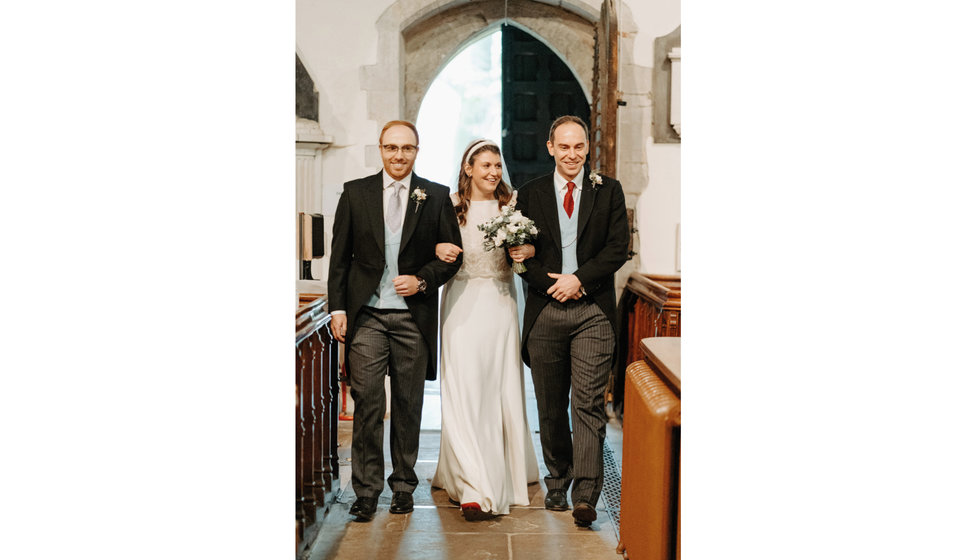 Sarah walking down the aisle with her two brothers.