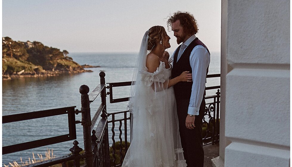 Jessica & Jack’s Idyllic Seaside Wedding in Cornwall: Jack & Jessica on the hotel's balcony