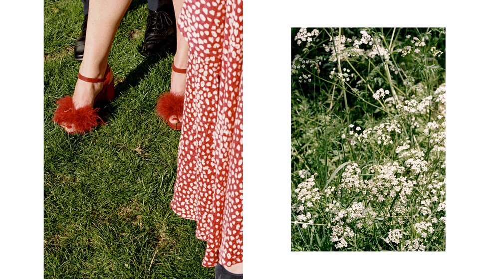 Charlotte & Harry's Magical Meadow Marquee Wedding in Oxfordshire: Details from the wedding location capturing guest's bright red fluffy heels and wild meadow flowers