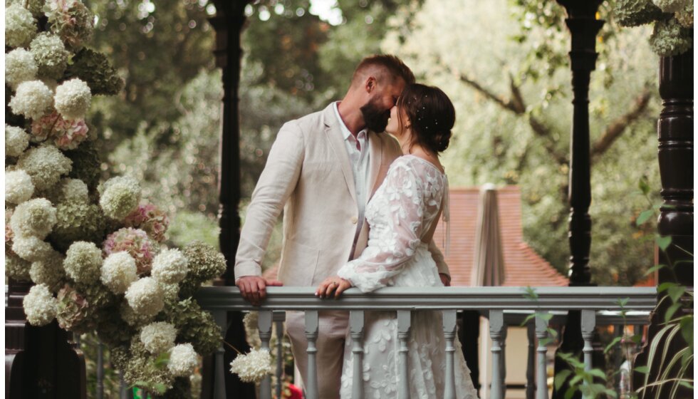 Whimsical Floral Wedding in London Park | The bride and groom kissing in a flower-decorated bandstand in Myatt's Field Park