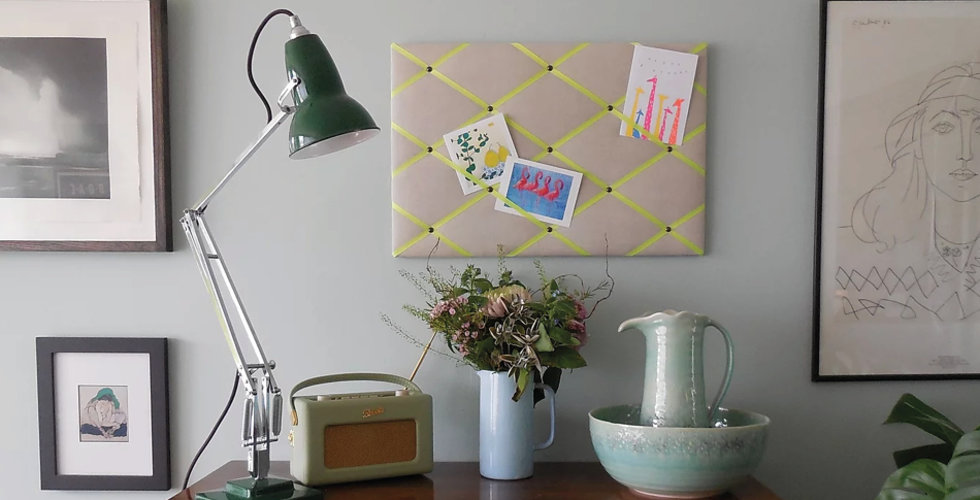 An interiors shot of a notice board on the wall above a side board.