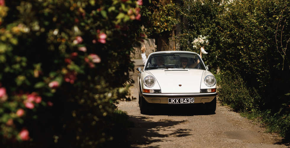 The bride and her father arriving to the church in a white vintage 911.